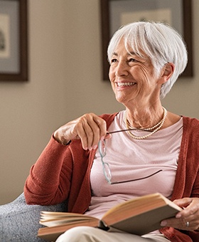 Senior woman reading in chair and smiling