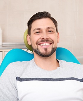 Male dental patient smiling in dental chair