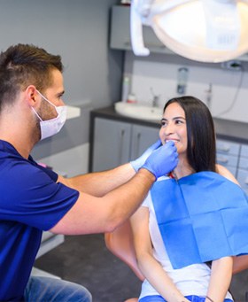 Dentist looking at smiling patient's teeth